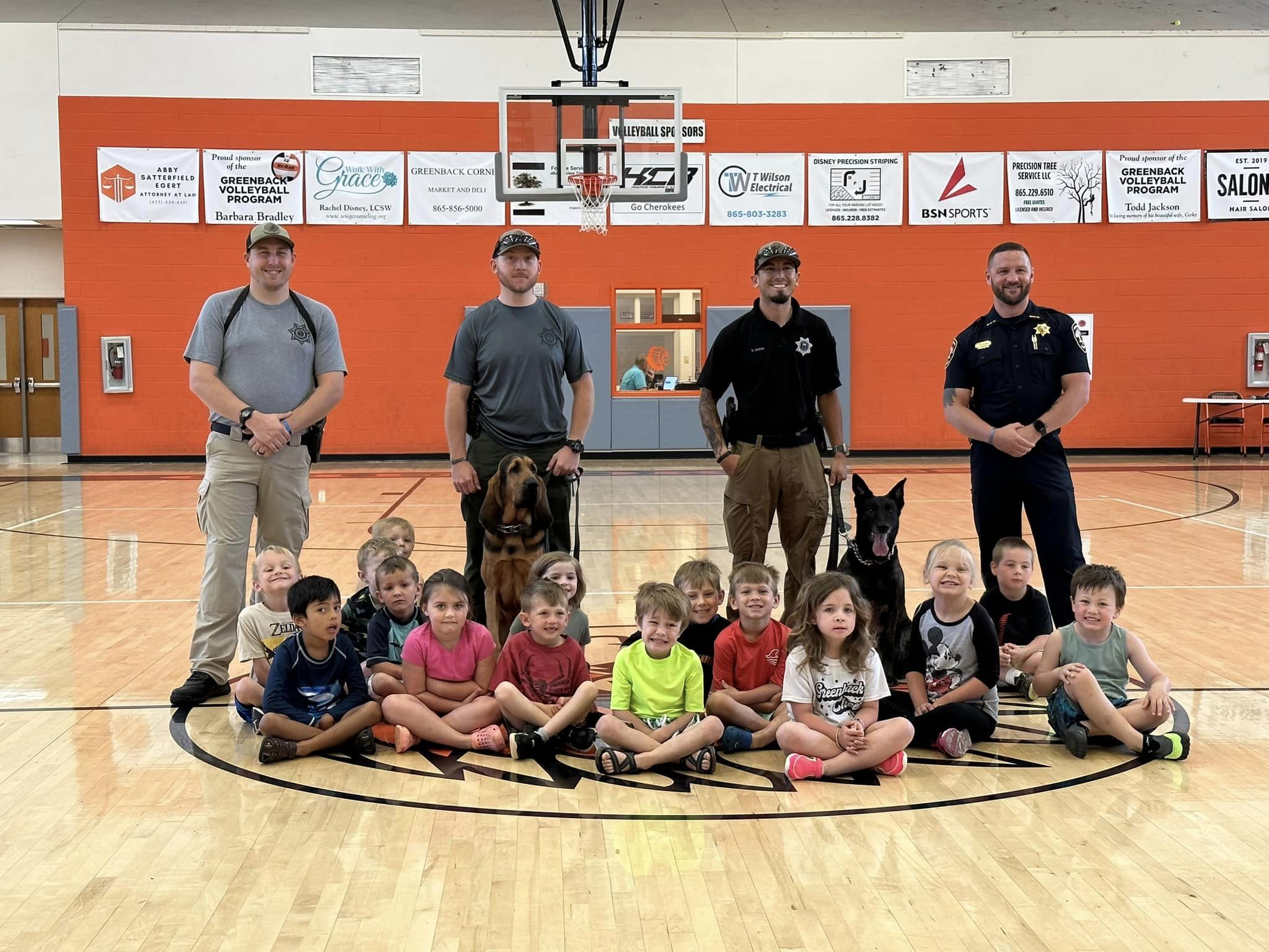 Officers and school children sitting in the gym